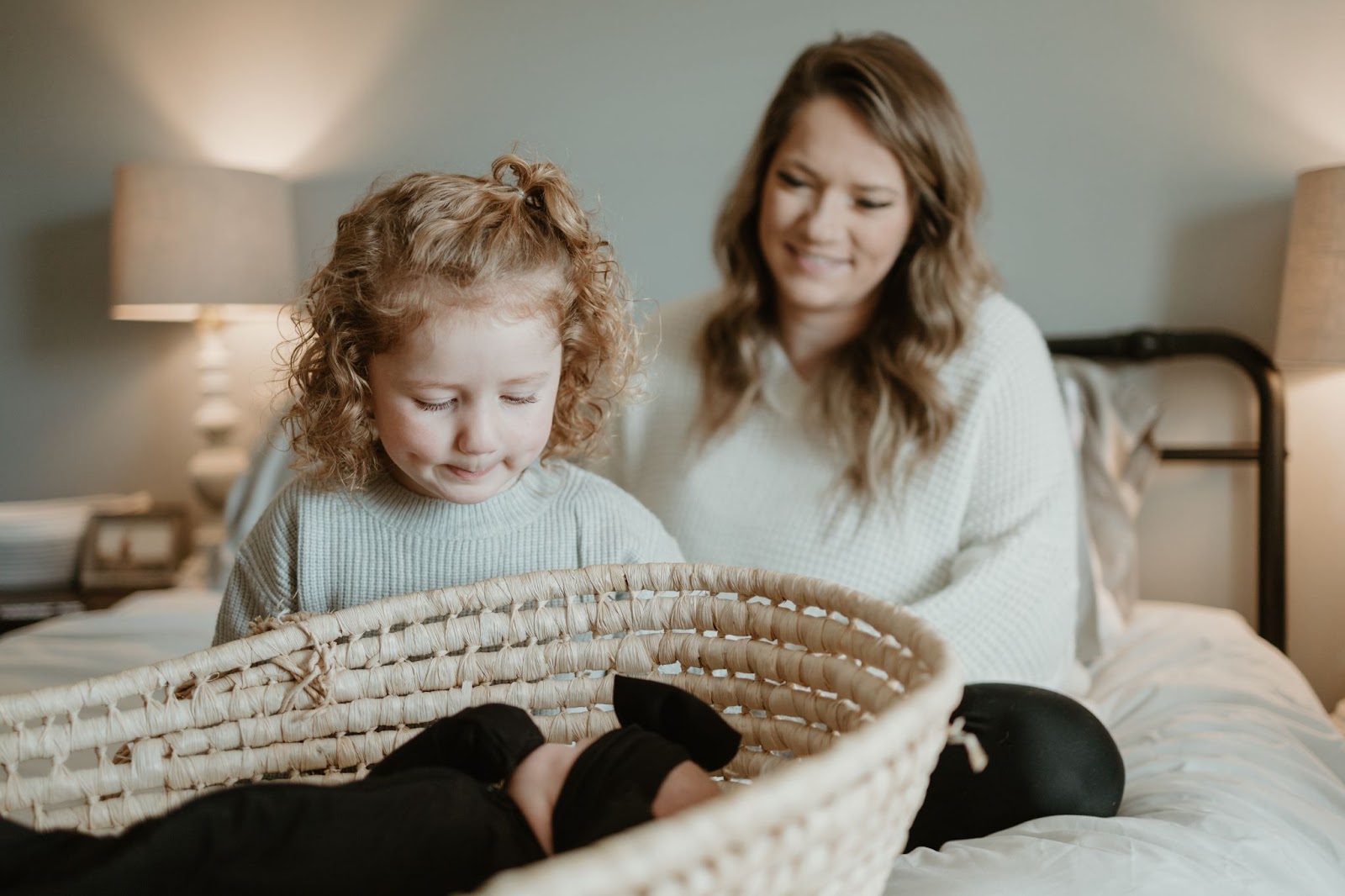 Mother and daughter looking at newborn baby, lovingly