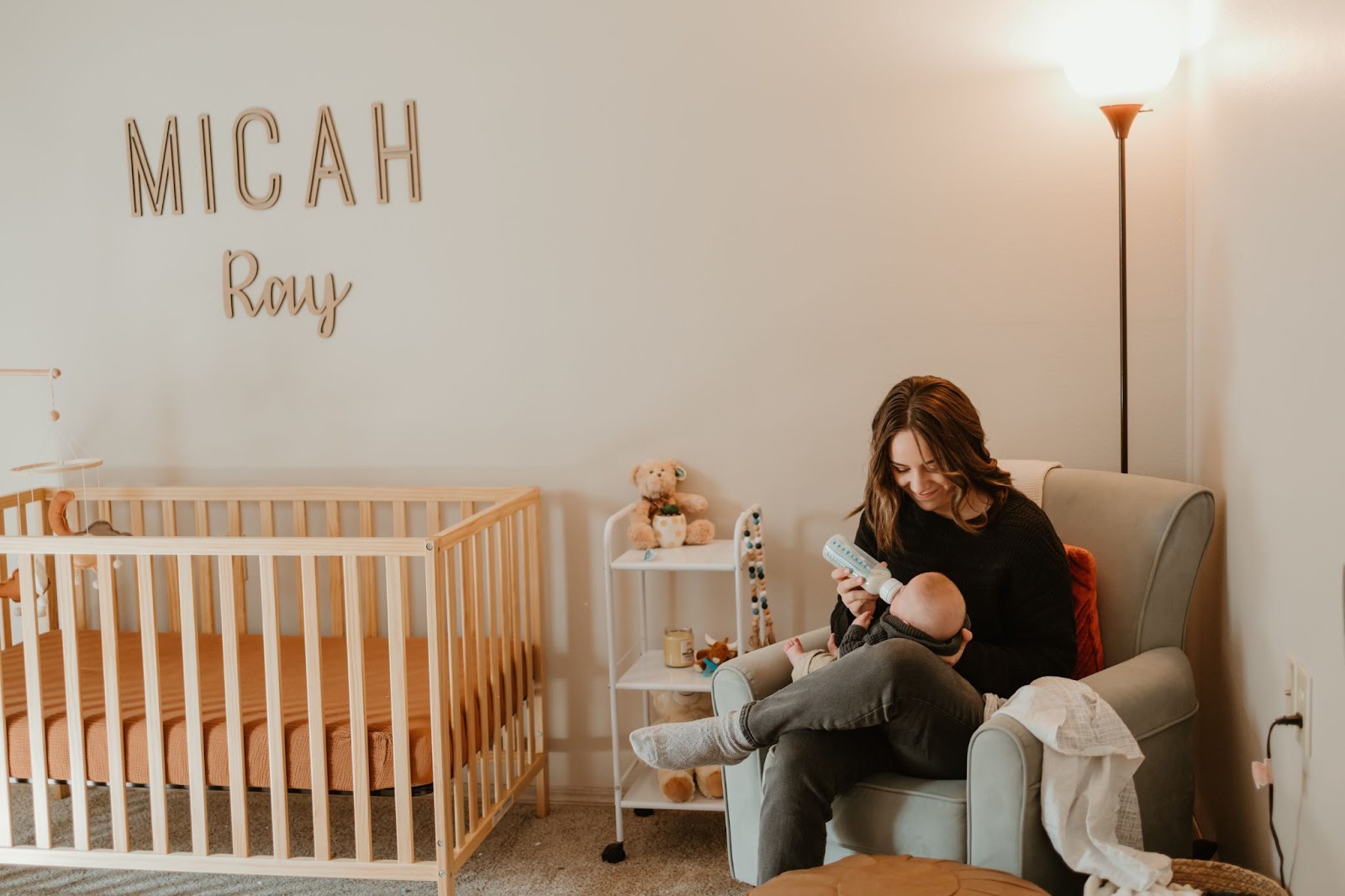 Young mother feeding baby in nursery